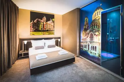 a bedroom with a bed and a painting on the wall at Central Point Boutique Hotel in Sofia