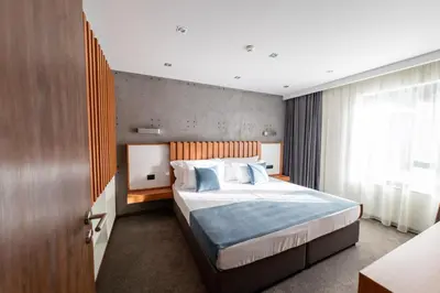 a bedroom with a large bed and a window at 103 Degrees Hotel & Spa in Sapareva Banya