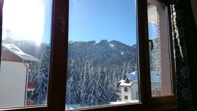 a view of a snowy mountain from a window at TES Rila Park Apartments in Borovets