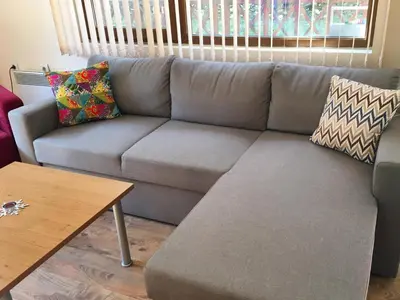 a gray couch in a living room with a table at Snow Apartment - Bansko in Bansko
