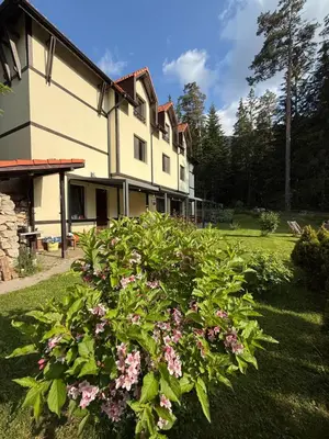 a house with a bush of flowers in the yard at Berghof Eva - Hotel in Panichishte