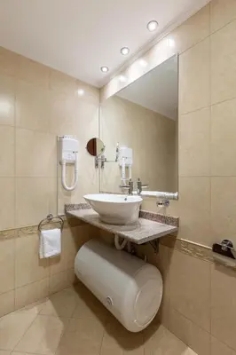 a bathroom with a sink and a large mirror at Downtown Bansko Resort in Bansko