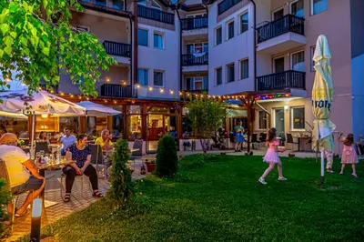 a group of people sitting outside of a building at Thermal Hotel Seven Seasons in Banya