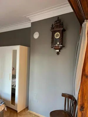 a clock on the corner of a wall next to a mirror at Your Space in Sofia in Sofia