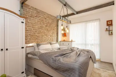 a bedroom with a bed with a brick wall at The Balkan in Plovdiv