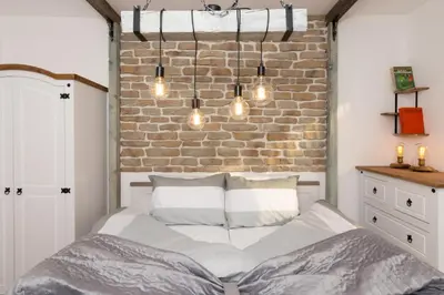 a bed in a bedroom with a brick wall at The Balkan in Plovdiv