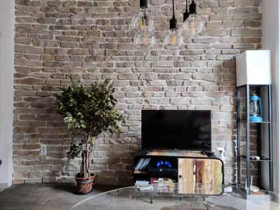 a living room with a brick wall and a tv at The Balkan in Plovdiv