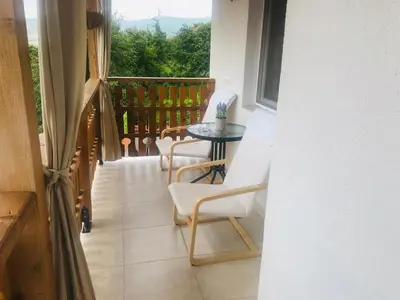 a balcony with a table and chairs and a window at Guest house Grahlyov in Sapareva Banya