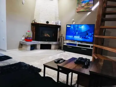 a living room with a television and a fireplace at Guest house Grahlyov in Sapareva Banya