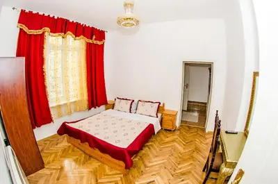 a bedroom with a bed and a red curtain at Central GuestHouse Five Corners in Sofia