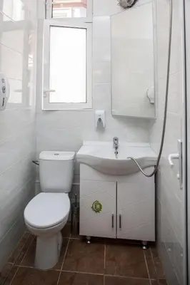 a white bathroom with a toilet and a sink at Central GuestHouse Five Corners in Sofia