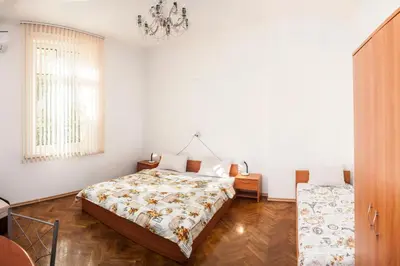 a bedroom with a bed and a chandelier at Central GuestHouse Five Corners in Sofia