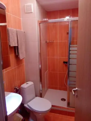 a bathroom with a shower and a toilet and a sink at Студио Бижу in Hisarya