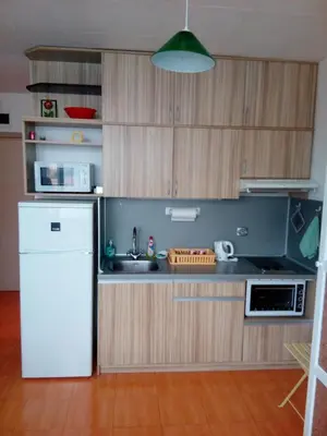a kitchen with a white refrigerator and a sink at Студио Бижу in Hisarya