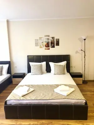 a bedroom with a large bed with two towels on it at Family Hotel Ring & Thermal in Kyustendil