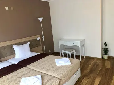 a bedroom with two beds and a table and a lamp at Family Hotel Ring & Thermal in Kyustendil