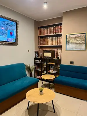 a living room with a blue couch and tables at Family Hotel Ring & Thermal in Kyustendil