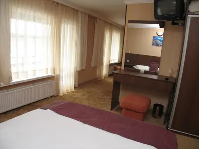 a hotel room with a bed and a sink and a mirror at Family Hotel Yagoda88 in Sofia