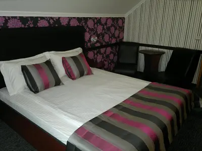 a bedroom with a large bed with two pillows at Family Hotel Yagoda88 in Sofia