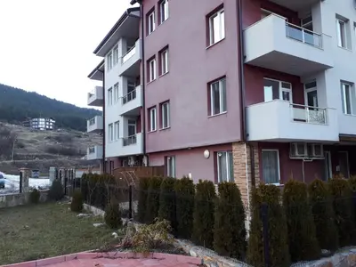 a pink building with a fence in front of it at ApartVel apartment 1 in Velingrad