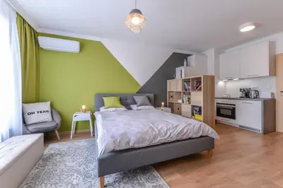 a bedroom with a large bed and a kitchen at The Spot - fully equipped, central, modern studio by Flat Mаnager in Sofia
