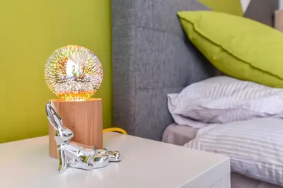 a lamp on a table next to a bed at The Spot - fully equipped, central, modern studio by Flat Mаnager in Sofia