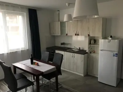 a kitchen with a table and a white refrigerator at ApartVel apartment 2 in Velingrad