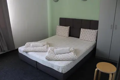 a bedroom with a bed with pillows on it at Hotel Color in Asenovgrad