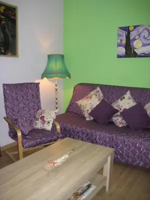 a living room with a purple couch and a table at Maria Louisa Apartment in Sofia
