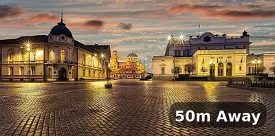 a large building with lights in a city at dusk at Exceptional Refurnished Studio TOP Location in Sofia