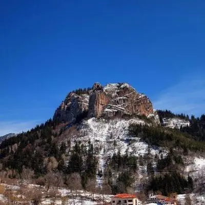 a mountain with a house in front of it at Ribkata Family Hotel in Smolyan