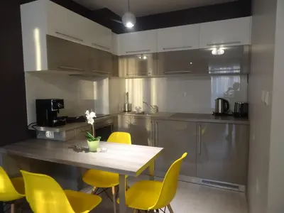a kitchen with a wooden table and yellow chairs at Апартамент 13 in Hisarya