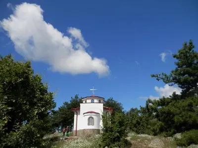 a small white building with a cross on top of it at Апартамент 13 in Hisarya