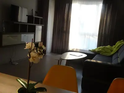 a living room with a couch and a table at Апартамент 13 in Hisarya