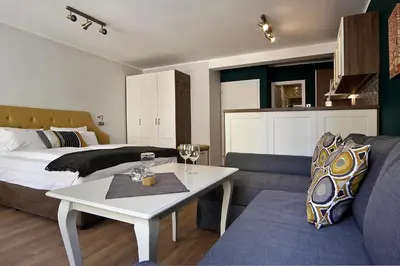 a living room with a bed and a table and a couch at Momenti & Colori Studios in Sofia