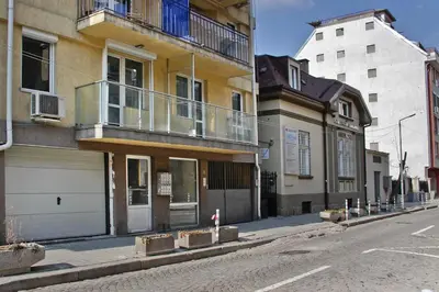 an empty street with a building with a balcony at Momenti & Colori Studios in Sofia