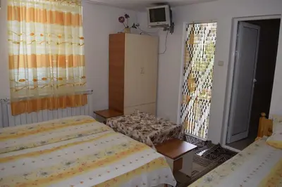 a bedroom with two beds and a tv in it at Стаи за гости 