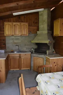 a kitchen with wooden cabinets and a stove top oven at Стаи за гости 