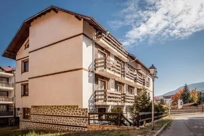 a building with wooden balconies on the side of it at Green Orange Apartment in Bansko