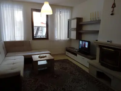 a living room with a couch and a tv at Apartment Аlex in Grand Monastery Pamporovo in Pamporovo