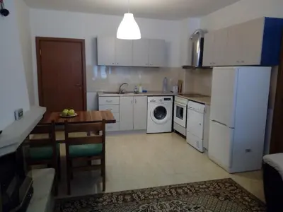 a kitchen with white appliances and a table and a dining room at Apartment Аlex in Grand Monastery Pamporovo in Pamporovo