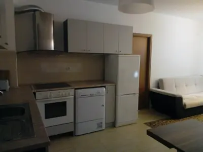 a kitchen with white appliances and a couch in a room at Apartment Аlex in Grand Monastery Pamporovo in Pamporovo