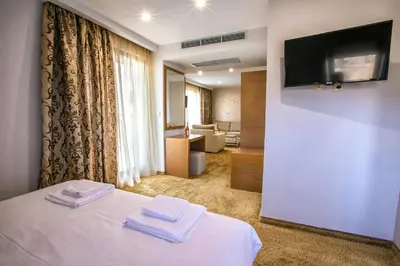 a hotel room with a bed with two towels on it at Hotel Andon Angelov in Sandanski