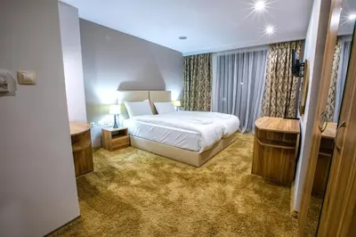 a hotel room with a bed and a window at Hotel Andon Angelov in Sandanski