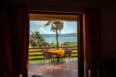 a table and chairs on a patio with a view of the water at Guest house Lidia in Tsigov Chark