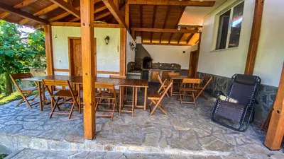 a wooden table and chairs on a patio at Guest House Au Nature in Golyama Zhelyazna