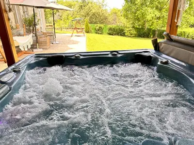a hot tub filled with water in a yard at Guest House Au Nature in Golyama Zhelyazna