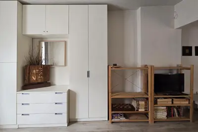 a living room with white cabinets and a tv at Red Door Apartment in Sofia