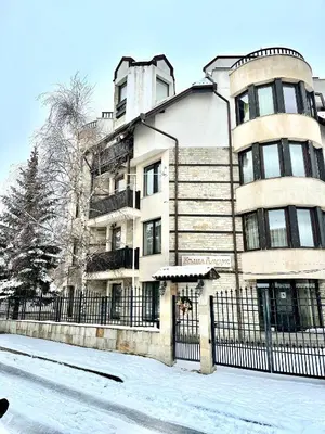 a building with a fence in the snow at House Laudis in Bansko