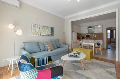 a living room with a blue couch and a table at Two Bedroom Apartment Near to Doctors Garden in Sofia